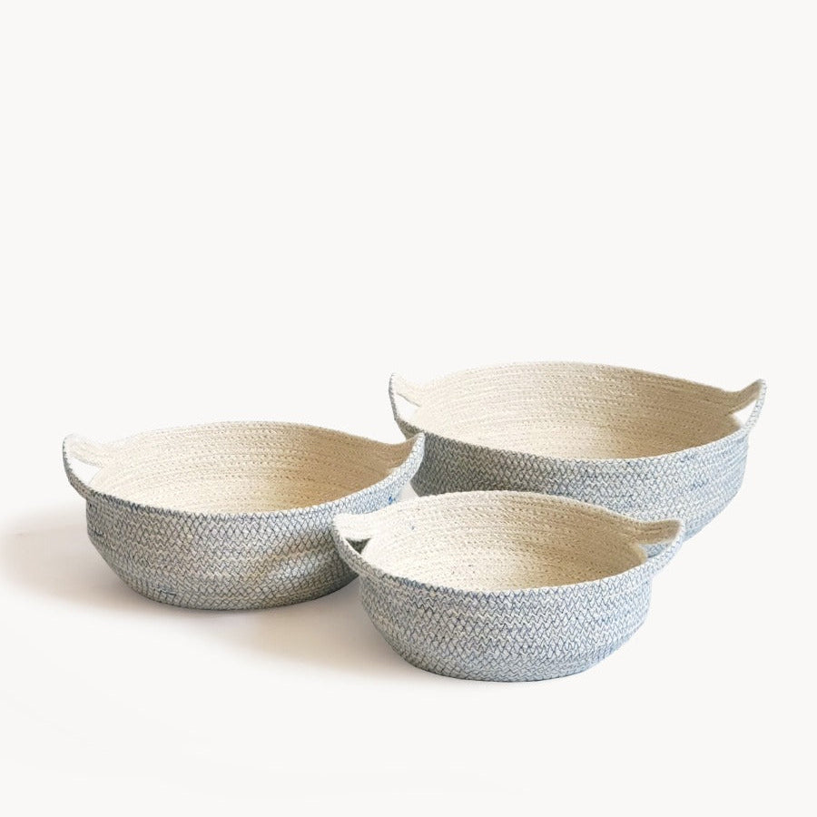 Three round, handwoven jute baskets with blue stitching, in varying sizes, displayed against a white background.
