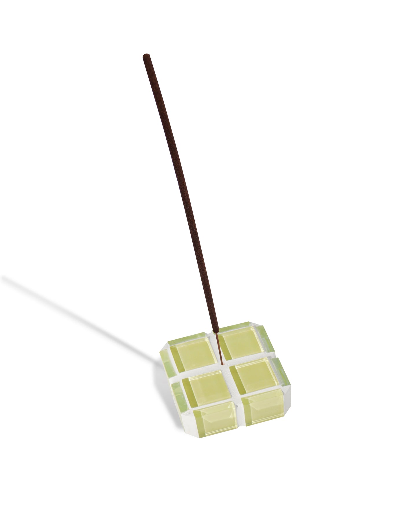 A yellow glass-tiled cube incense holder holding a single incense stick.