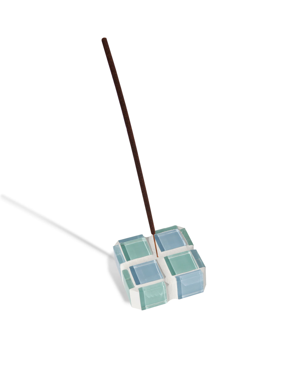 A blue and teal glass-tiled incense holder holding a single incense stick.