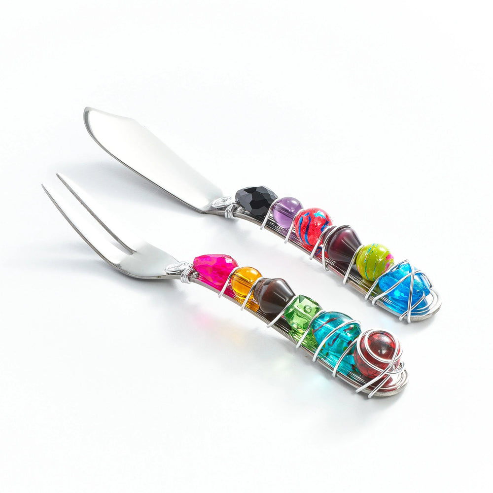 Set of stainless steel cheese cutlery with colorful gemstone handles on a white background