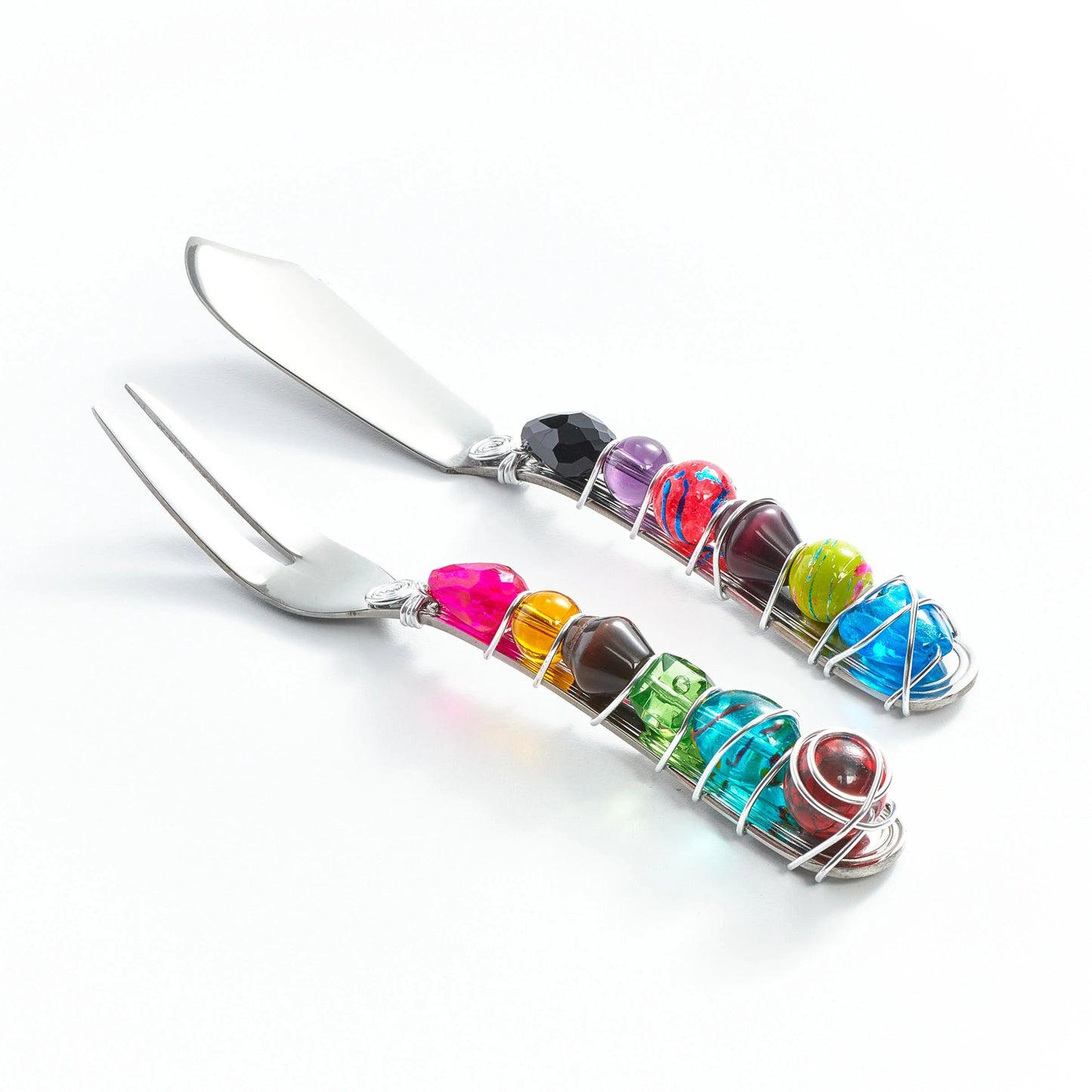 Set of stainless steel cheese cutlery with colorful gemstone handles on a white background