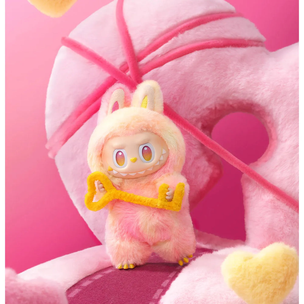 
                      
                        The MONSTERS Big Into Energy series LOYALTY Labubu with a key on a pink background
                      
                    