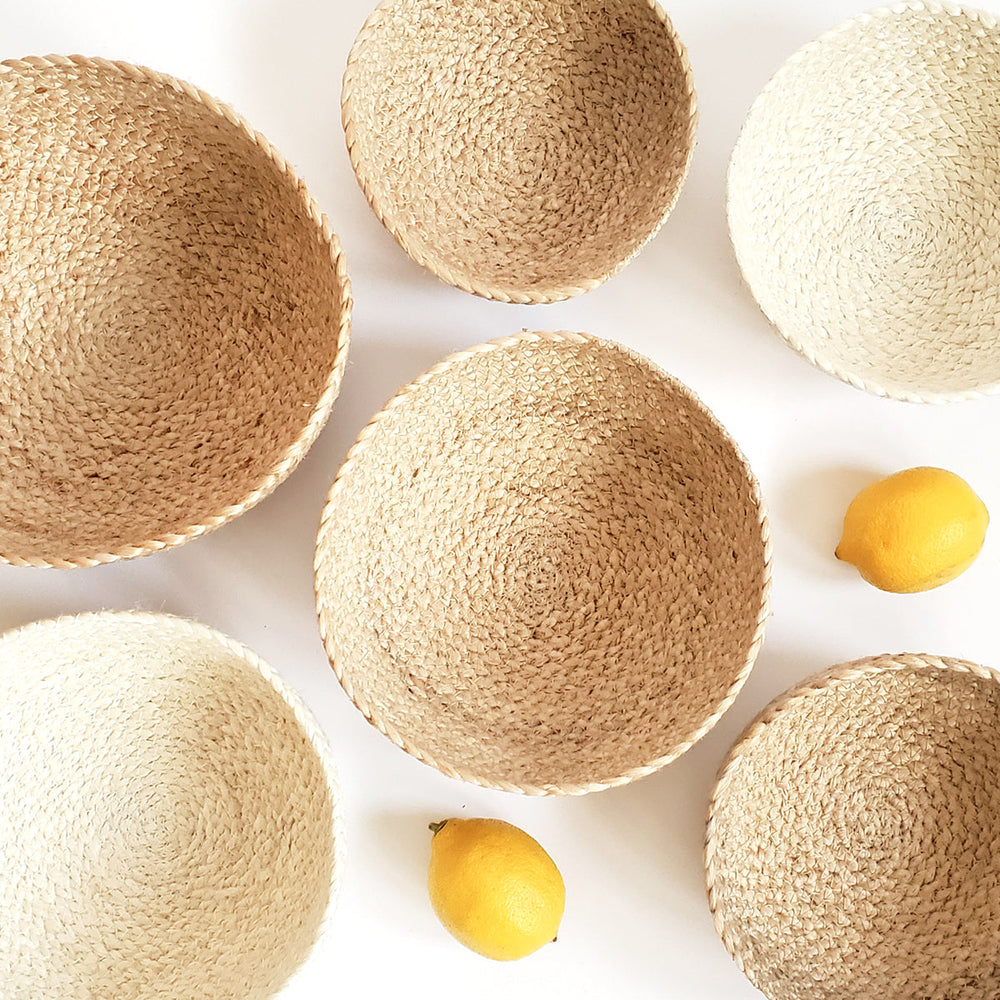 Woven bowls of various sizes on a white background with lemons.