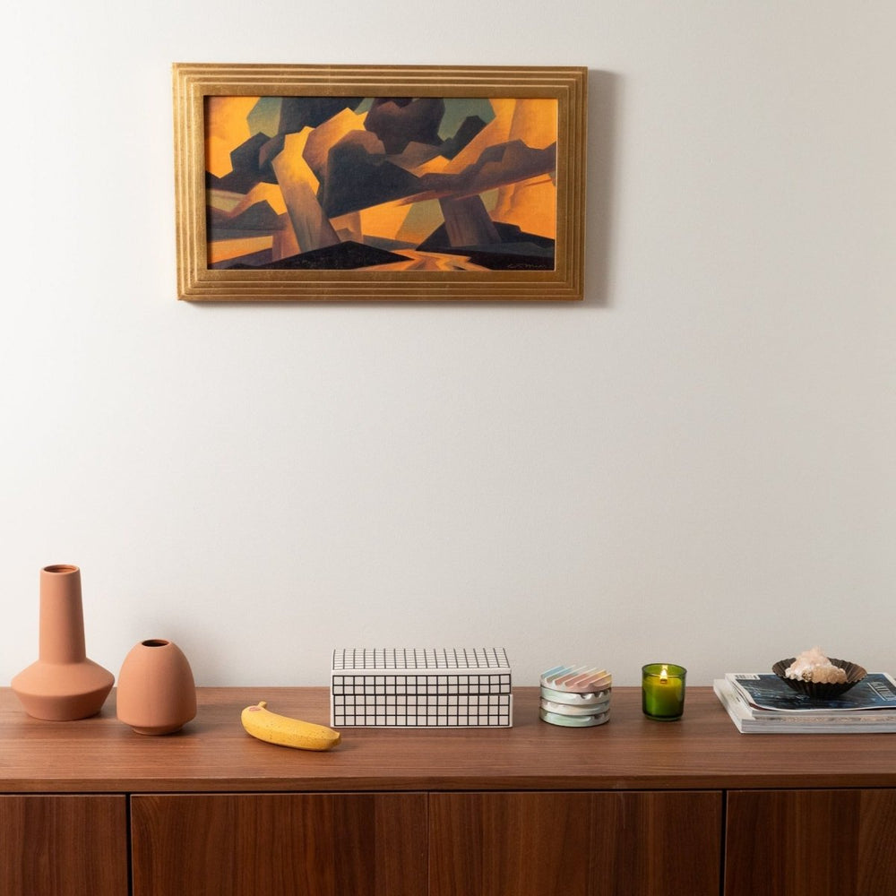
                      
                        A perfectly ripe concrete banana on a wood sideboard next to other decorative items.
                      
                    