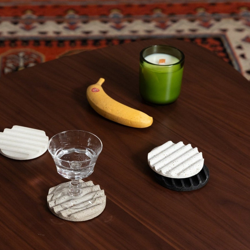 
                      
                        A perfectly ripe concrete banana on a wood table next to other decorative items.
                      
                    