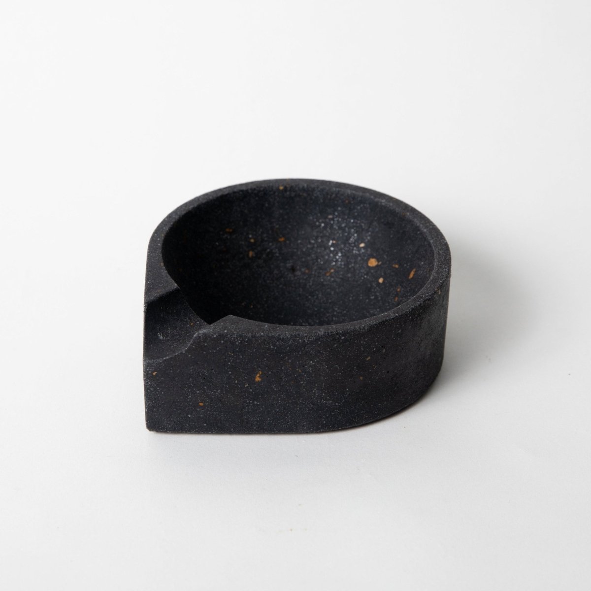 Concrete cigar ashtray in black terrazzo against a white background