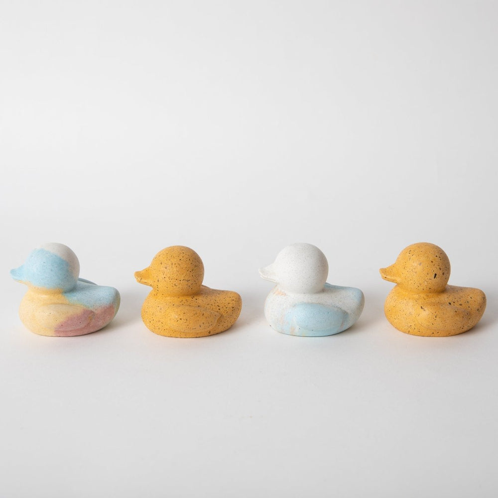 
                      
                        Four trailing mini concrete rubber duckies in jawbreaker and marigold terrazzo
                      
                    