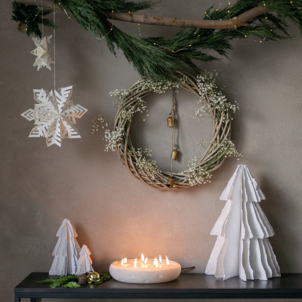 
                      
                        Flurry™ Hanging Paper Snowflakes styled above lit candle and holiday decorations.
                      
                    