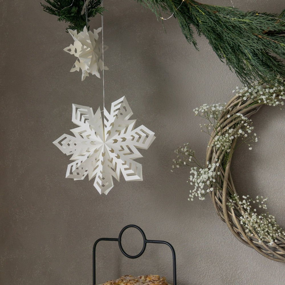 
                      
                        Two Flurry™ Hanging Paper Snowflakes against a gray wall.
                      
                    