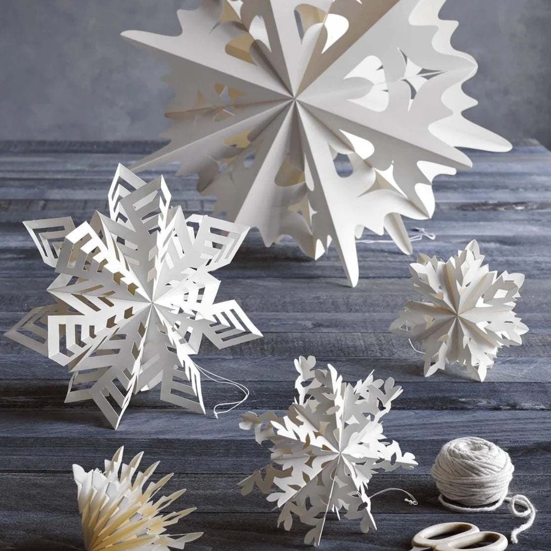 An assortment of Flurry™ Hanging Paper Snowflakes from texxture